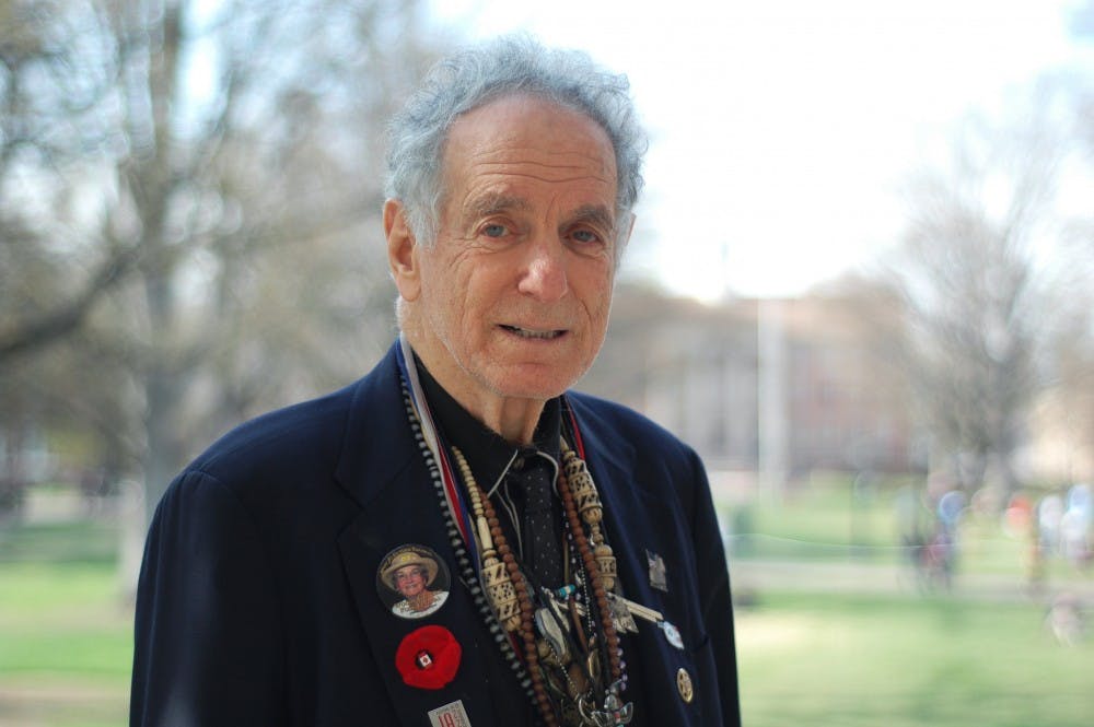 David Amram stands with a necklace made by his daughter from assorted trinkets and collectibles he has be given and found over the years. Amram has spent his life doing many types of things, most notably his musical career with multiple instruments.