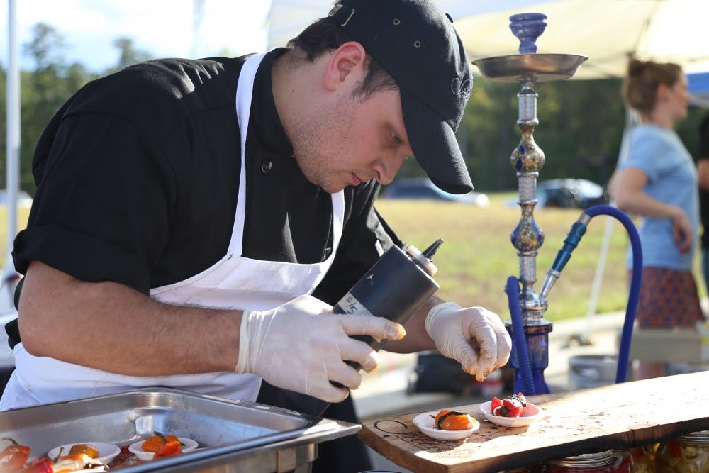 Patrick Ewald, the general manager of Sitti Restaurant in Raleigh, prepares a sample of mini sweet bell peppers stuffed with goat cheese and topped with a pomegranate balsamic vinaigrette. 

6th Annual Pepper Festival in Briar Chapel’s Boulder Park