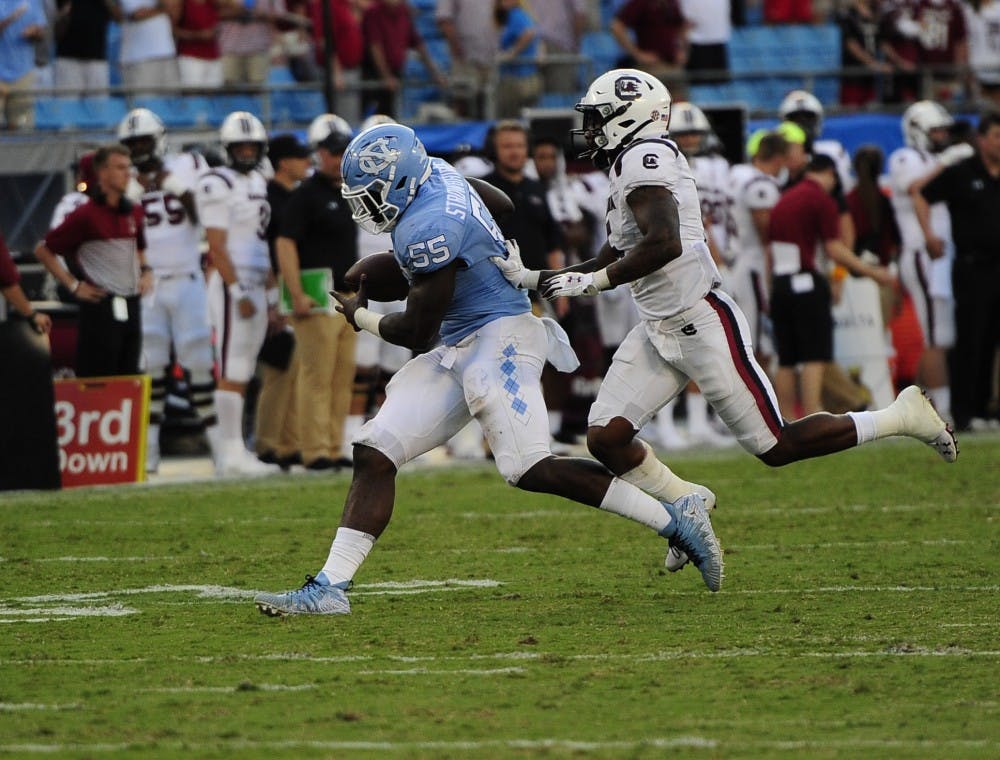 After intercepting a throw senior defensive lineman Jason Strowbridge (55) runs across the field for a touchdown with seconds left in the game during the Belk College Kick Off in Charlotte, NC on Saturday, August 31, 2019. UNC beat the University of South Carolina 24-20. 