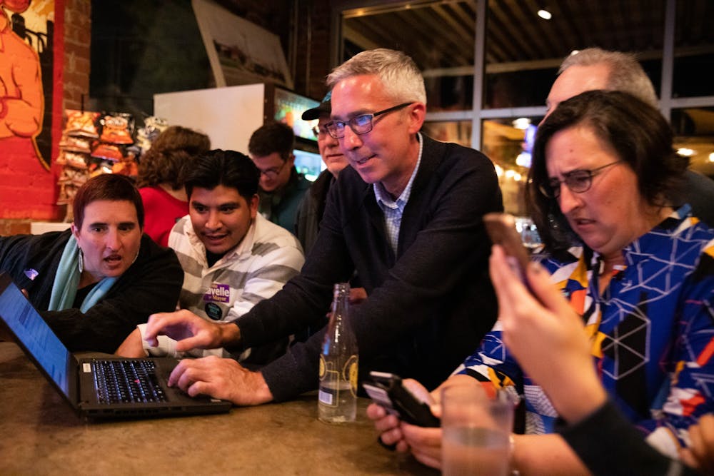 (From left) Allison De Marco, 45, Eliazar Posada, 27, alderman candidate Damon Seils and Molly De Marco, 45, watch local election results during an election party organized by Seils' campaign at Steel String Brewery in Carrboro on Tuesday, Nov. 5, 2019.