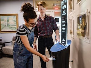 Seniors Ellie Rodriguez and Hampton Smith use the new Short Story Dispenser coming to UNC's campus this week.&nbsp;
Photo courtesy of Johnny Andrews, UNC-Chapel Hill