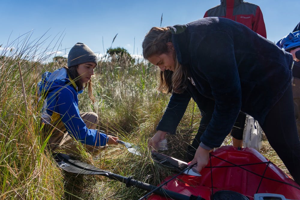 <p>UNC sophomore Emma Rudy Srebnik and senior Jenna Hynes measure and collect samples from a sediment core as part of their capstone research on Oct. 27, 2021. This year's capstone partnered students with the National Park Service to study the impacts of Hurricane Dorian on Core Banks of the Cape Lookout National Seashore. Photo courtesy of Morgan Pirozzi.&nbsp;</p>