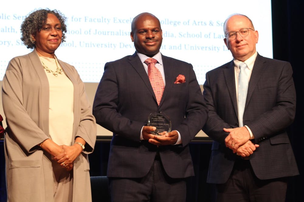 Dr. Nate Thomas III, standing between Dr. Leah Cox and Provost Chris Clemens, receives the Unsung Hero Award during the 41st Annual Martin Luther King, Jr. Keynote Lecture and Awards Ceremony on Feb. 22, 2022 in the Carolina Union Great Hall.