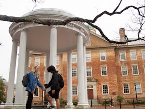 A UNC Couple holds hands in front of the Old Well on Wednesday, Feb. 13, 2020. Many couples will be celebrating Valentine's Day together and are reflecting on how they met on UNC's campus.