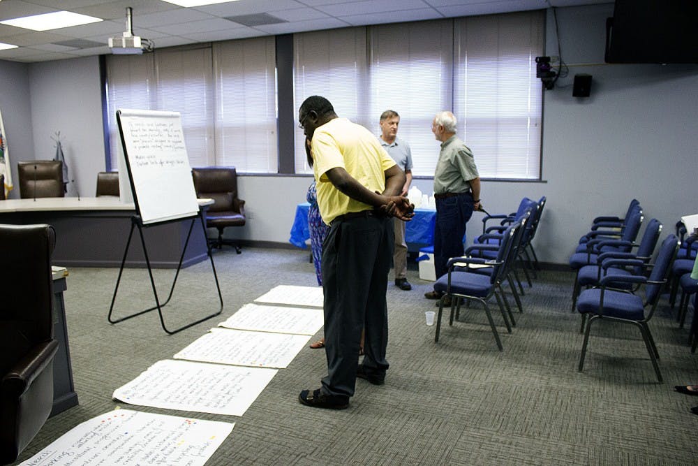 <p>Members of the steering project speak with residents of the community about the proposed arts and creativity district.</p>
