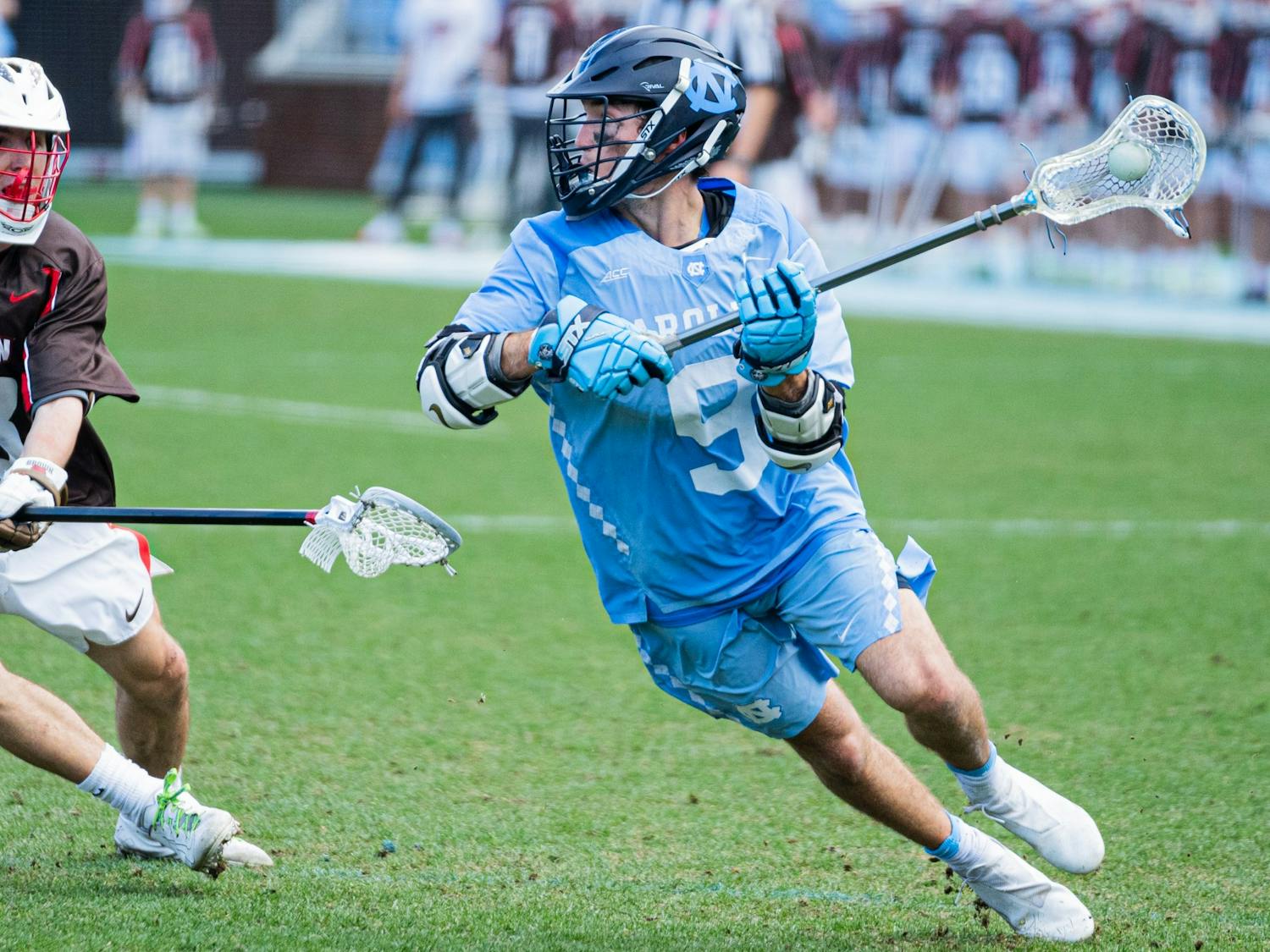 Senior attackman Jacob Kelly (9) looks to cross the ball during a men's lacrosse game in Dorrance Stadium against Brown University on Wednesday, Feb. 23, 2022. UNC won 14-11.