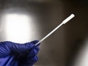 DTH Photo Illustration depicting a nasal swab used for COVID-19 testing.