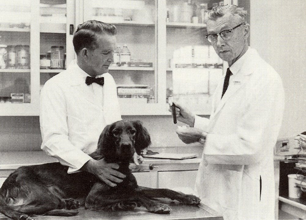 Kenneth Brinkhous (right) began studying the first known canine carriers of hemophilia in 1947. His research with dogs led to the creation of a blood laboratory, known today as the Francis Owen Blood Research Laboratory — which led to multiple advancements in hemophilia including a blood test, treatments, and knowledge of the disease. (photo courtesy of the Francis Owen Blood Research Laboratory)