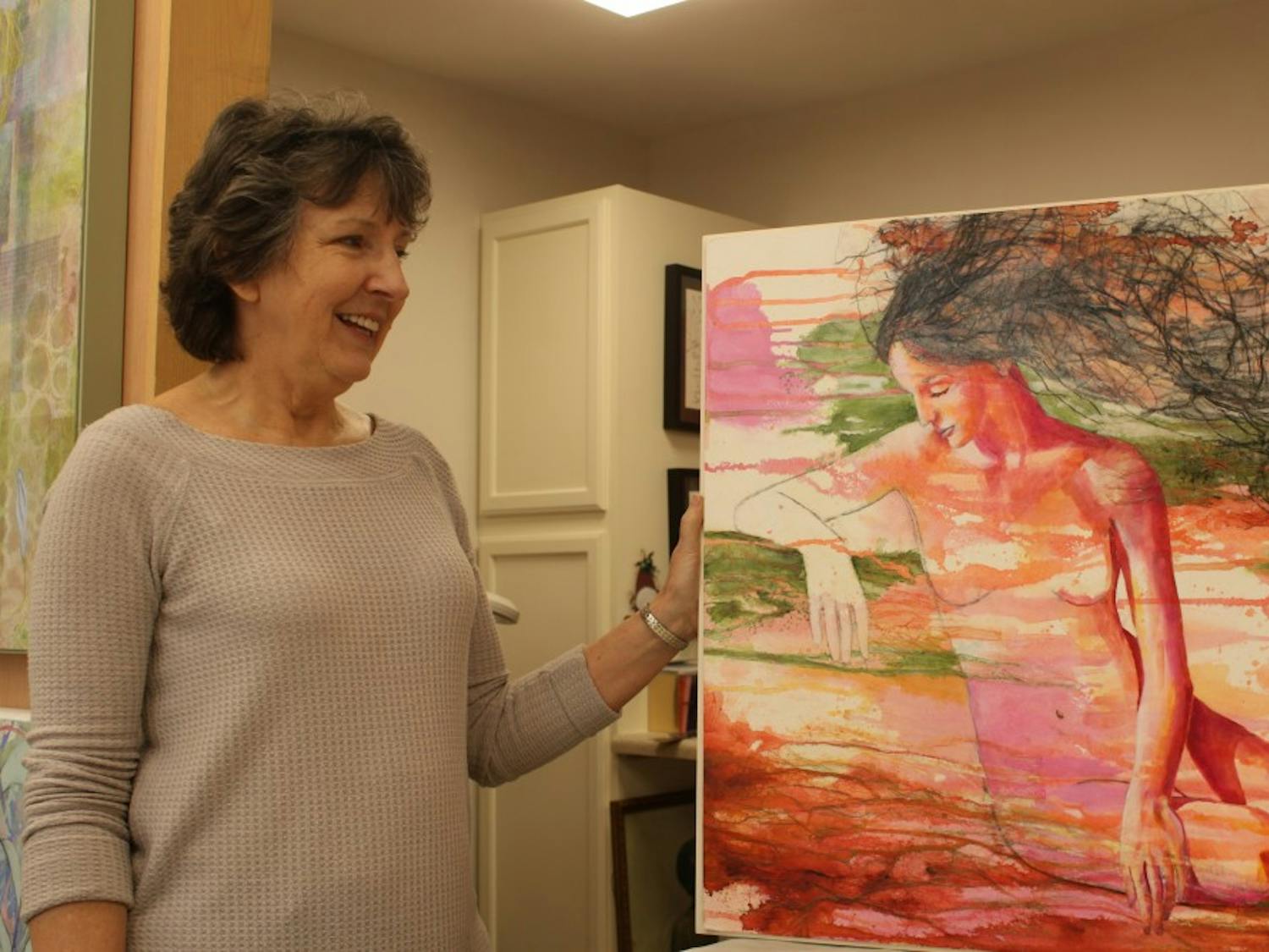 Visual artist Nancy Smith stands by her painting "From the Depths of the Earth" in her home studio on Saturday, March 2, 2019. Nancy's paintings, which were created using acrylic and mixed media, are being hosted by the FRANK gallery.&nbsp;