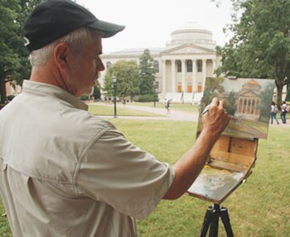 Robert Steele paints Wilson Library from Polk Place on Wednesday afternoon. 