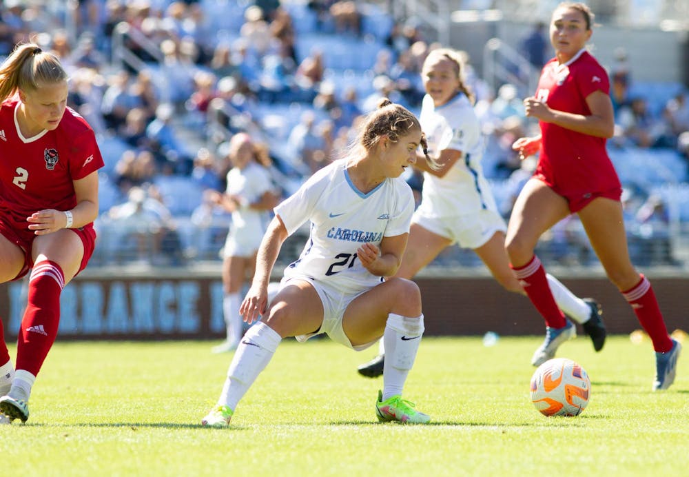 <p>UNC first-year forward Ally Sentnor (21) steals the ball during the women's soccer game against NC State on Sunday, Oct. 9, 2022, at Dorrance Field. UNC beat NC State 2-0.</p>