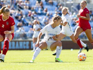 UNC freshman forward Ally Sentnor (21) steals the ball during the women's soccer game against NC State on Sunday, Oct. 9, 2022, at Dorrance Field. UNC beat NC State 2-0.