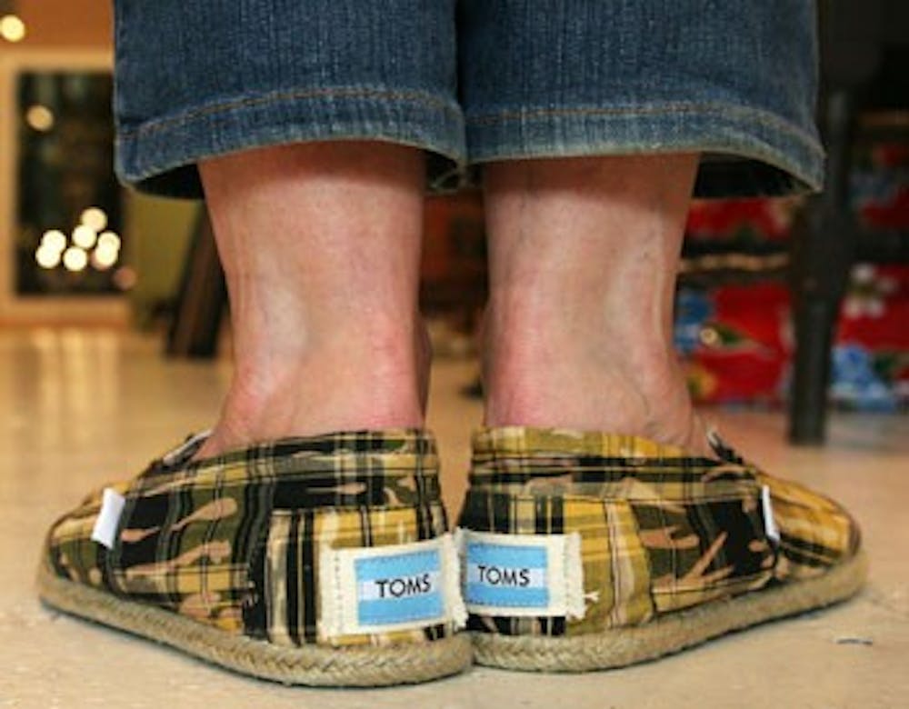 Maggie Pearson, or “Magoo” of the Toots & Magoo store, wears TOMS on Tuesday afternoon while working in the store. 