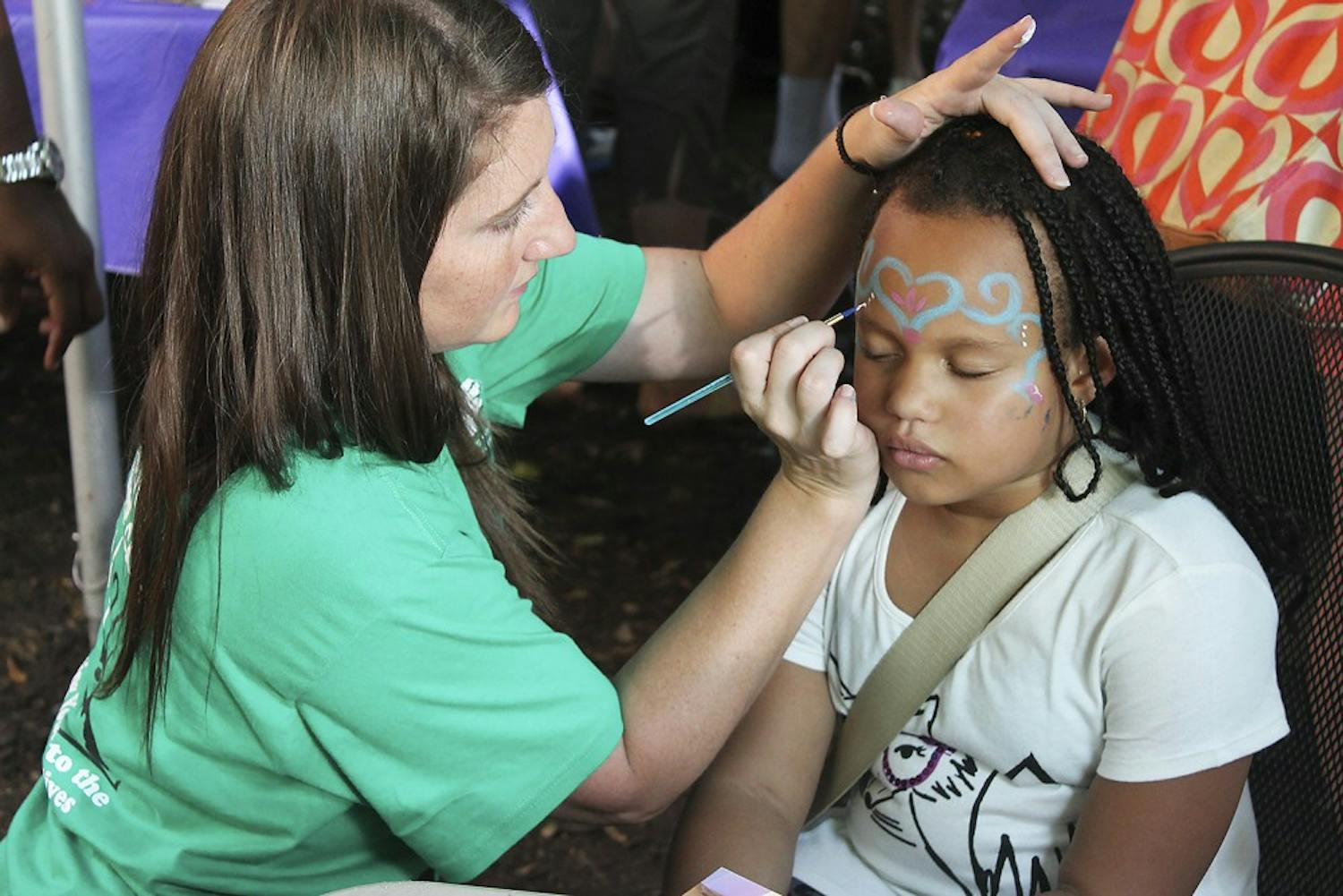 Laila Williams, eight years old, gets her face painted at the Weaver Street Co-Op Fair in Carborro.