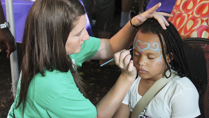 Laila Williams, eight years old, gets her face painted at the Weaver Street Co-Op Fair in Carborro.