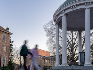 Students walk by the Old Well on Monday, Feb. 6, 2023.