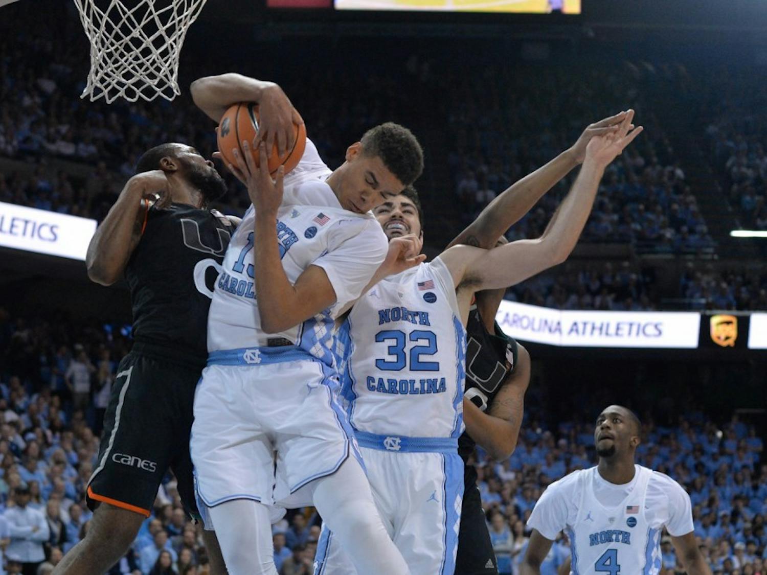 North Carolina guard Cam Johnson (13) goes for a rebound against Miami defenders on Feb. 27 at the Smith Center.