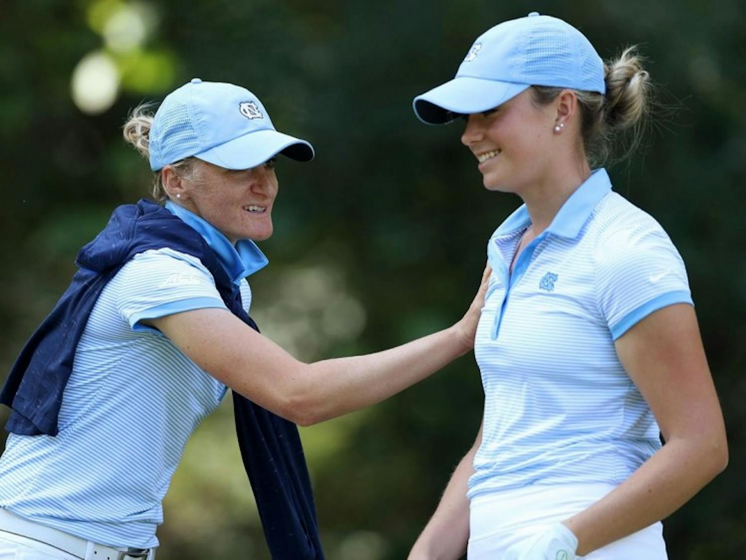 Junior golfer Kelly Whaley (right) jokes with associate head coach Aimee Neff during the Briar's Creek Invitational in March. Photo courtesy of UNC Athletic Department.