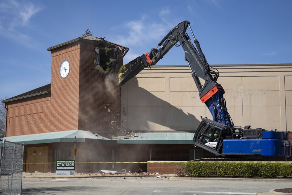 The former Southern Season building in Chapel Hill, N.C. gets demolished at the groundbreaking ceremony for University Place on Monday, Mar. 6, 2023. Construction will soon begin in its place for new living and recreational areas.