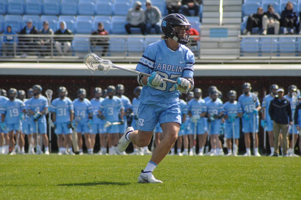 UNC junior midfielder Luca Antongiovanni (87) carries the ball down the field during the men's lacrosse game against Brown at Dorrance Field on Saturday, March 11, 2023. UNC won 19-6.