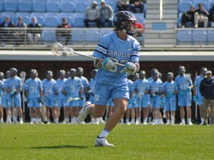 UNC junior midfielder Luca Antongiovanni (87) carries the ball down the field during the men's lacrosse game against Brown at Dorrance Field on Saturday, March 11, 2023. UNC won 19-6.