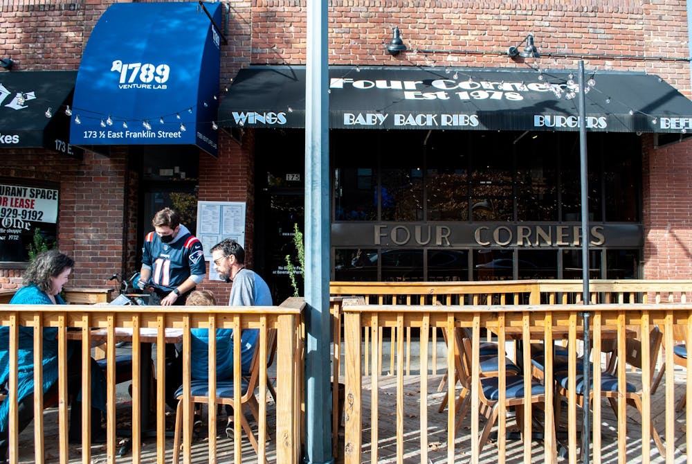 A family dines outdoors at Four Corners on Nov. 29, 2021. The restaurant and sports bar has faced staffing issues over the past year, along with other establishments on Franklin Street.