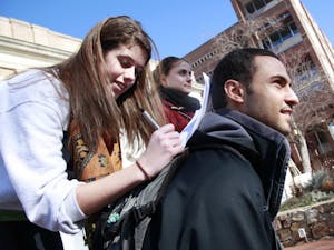 Hannah Sacco, junior at UNC-Chapel Hill, with the assistance of Mohammad Saad's back, fills out petitions for Student Body President and Senior Class Representatives on Jan. 19.