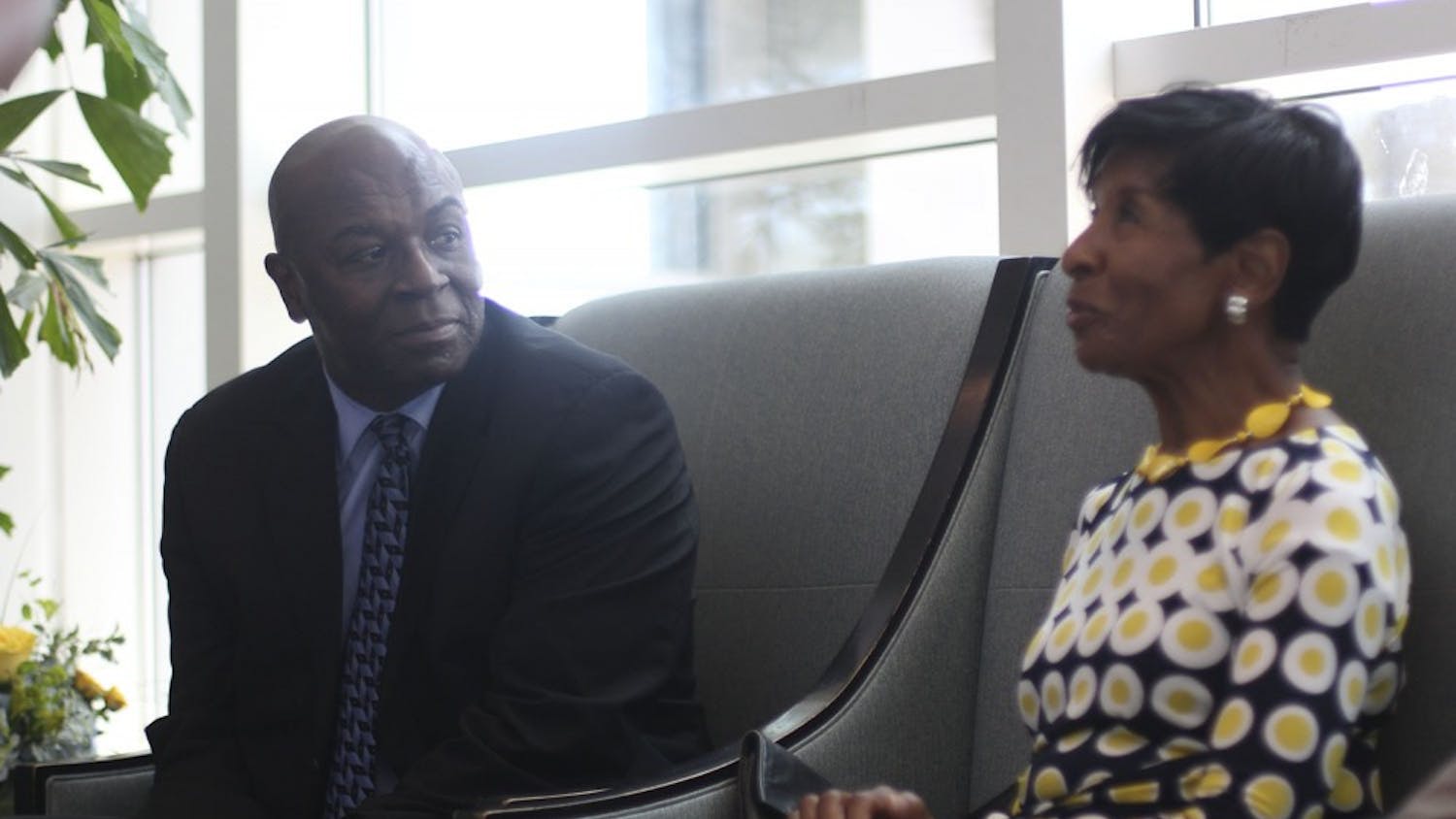 Former UNC men's basketball player Phil Ford listens as Esther Jones, a former school teacher who is pledging $1.4 million to his newly-formed professorship, talks to reporters.