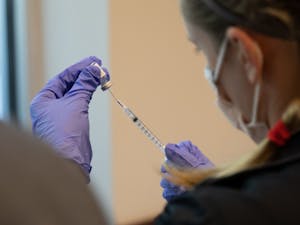 A volunteer fills a syringe with the COVID-19 vaccine at La Semilla's vaccination event, Feb. 20, 2021.