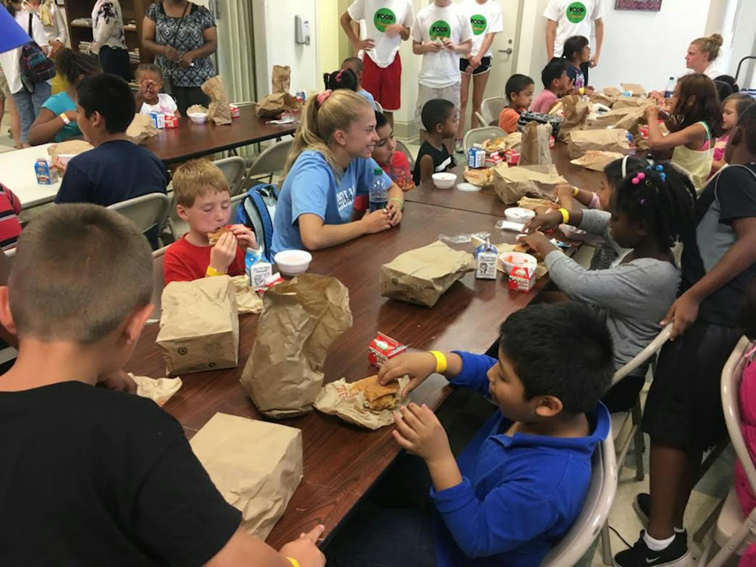 UNC women's soccer midfielder Megan Buckingham eats lunch with Food for the Summer attendees.&nbsp;Photo courtesy of the Town of Chapel Hill.