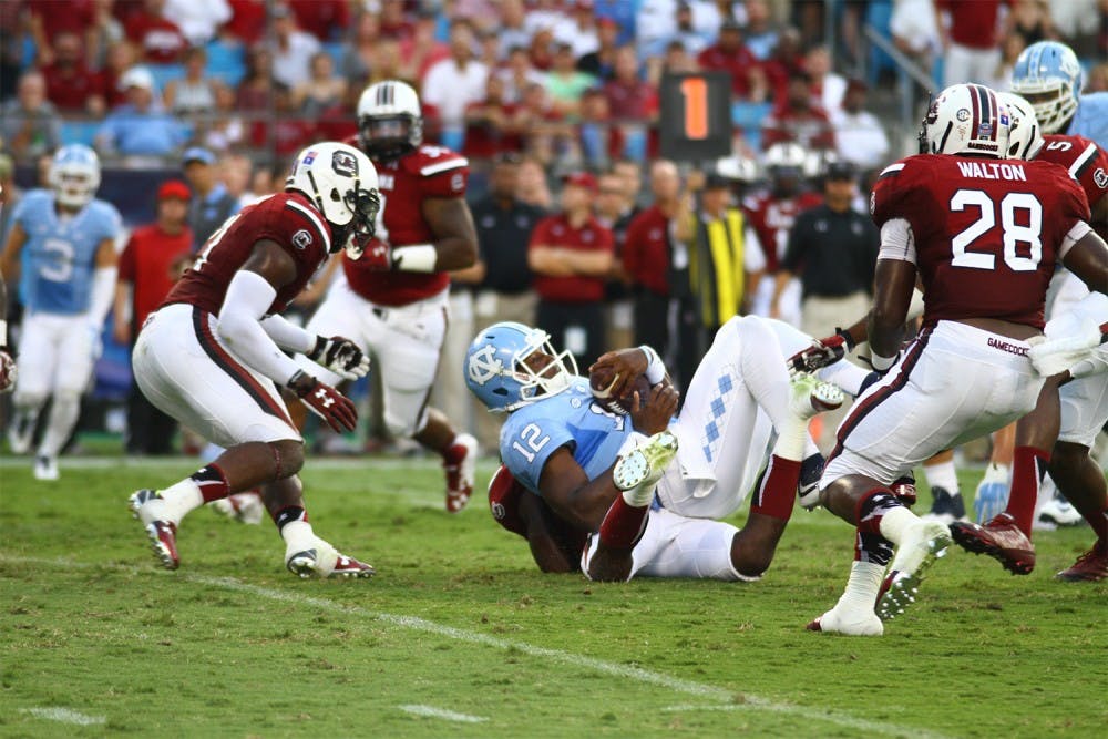 South Carolina surrounds senior quarterback Marquise Williams (12). Williams threw three interceptions on Sept. 3 in a 17-13 loss against the Gamecocks.