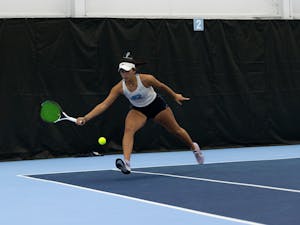 Sophomore Carson Tanguilig returning the serve during her singles match against Elon University at the Cone-Kenfield Tennis Center on  Friday, January 13, 2023. UNC beat Elon 4-2.