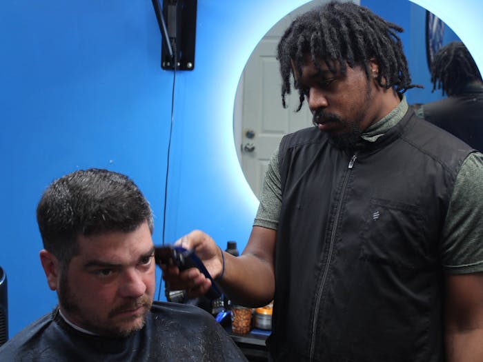 Kendrick Boulware, the owner of Kendrick's Kave Barbershop in Durham, NC, cuts a client's hair on Wednesday, Feb. 16, 2022. 