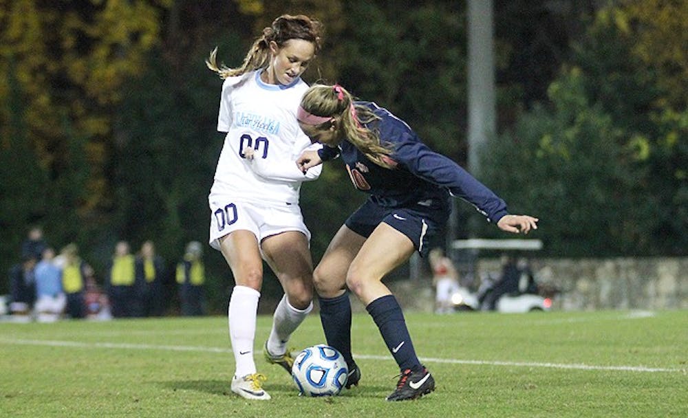 	UNC senior Alyssa Rich battles for possession against Illinois on Friday night. UNC won 9-2 to advance to Sunday’s third round game against Baylor.