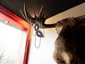 A mask and Mardi Gras beads hang from the antlers of a moose at Red Moose Brewing Company in Pittsboro, N.C. on Tuesday, Feb. 22, 2022. The family-owned establishment is one of many local businesses participating in the Pittsboro Mardi Gras Pub Crawl on Feb. 26, 2022.