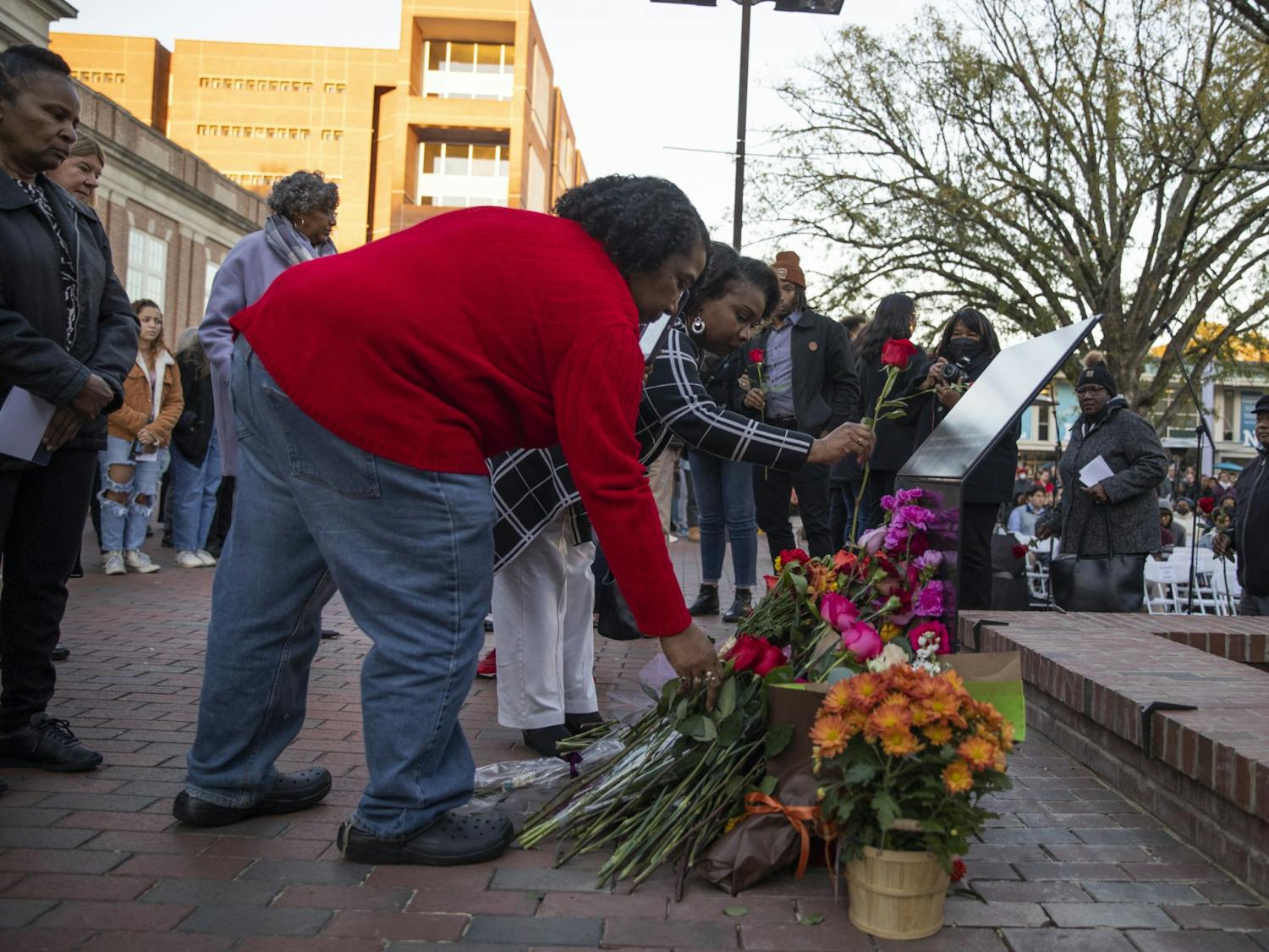 Family members and community members lay flowers at the memorial for James Lewis Cates, Jr. after its dedication on Monday, Nov. 21, 2022.