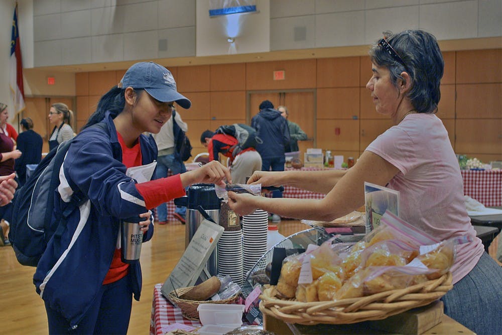 FLO Farmer's Market took place in the Great Hall Thursday afternoon after being moved there because of inclement weather. The market showcased different organic foods and produce from local vendors. Khin Oo, a sophomore health policy and management major samples food from Yugala's Kitchen from Carrboro, which featured coffee and homemade baked goods. "I usually go to this kind of stuff when they set it up so I don thane to go all the way to Carrboro on Satrudays." 

