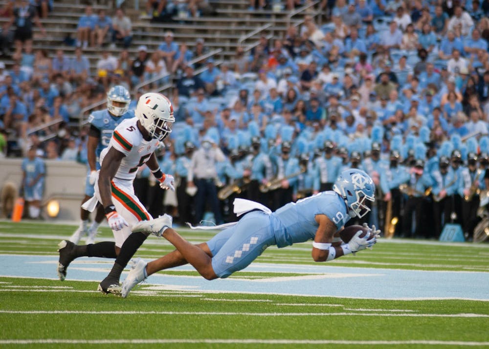 <p>Junior defensive back Cam'Ron Kelly (9) receives the ball during the Tar Heels' football game at Kenan Stadium on Oct. 16 against Miami. UNC won 45-42.</p>