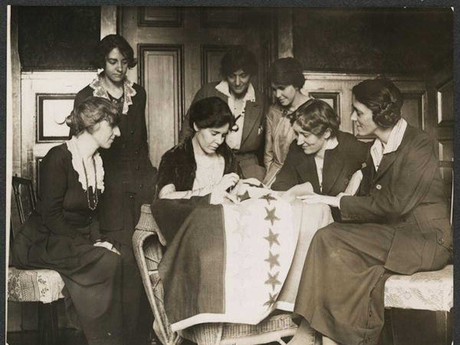 Alice Paul sews a star onto the NWP Ratification Flag, representing another state's ratification of the 19th Amendment. Photo courtesy of The Suffragist Project.