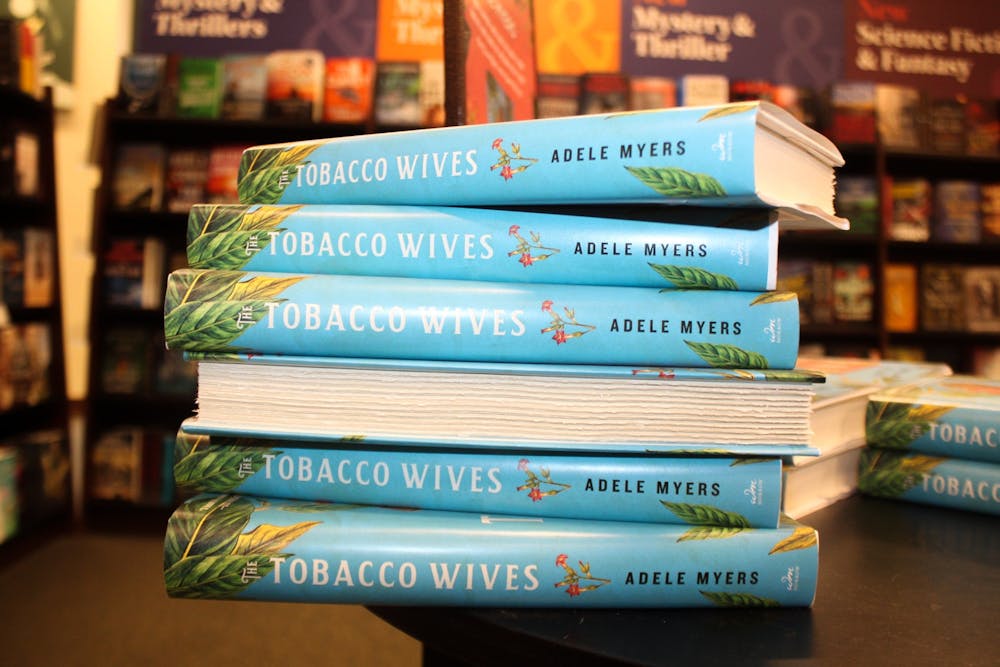DTH Photo Illustration. Several copies of 'The Tobacco Wives: A Novel' sit on a table. 