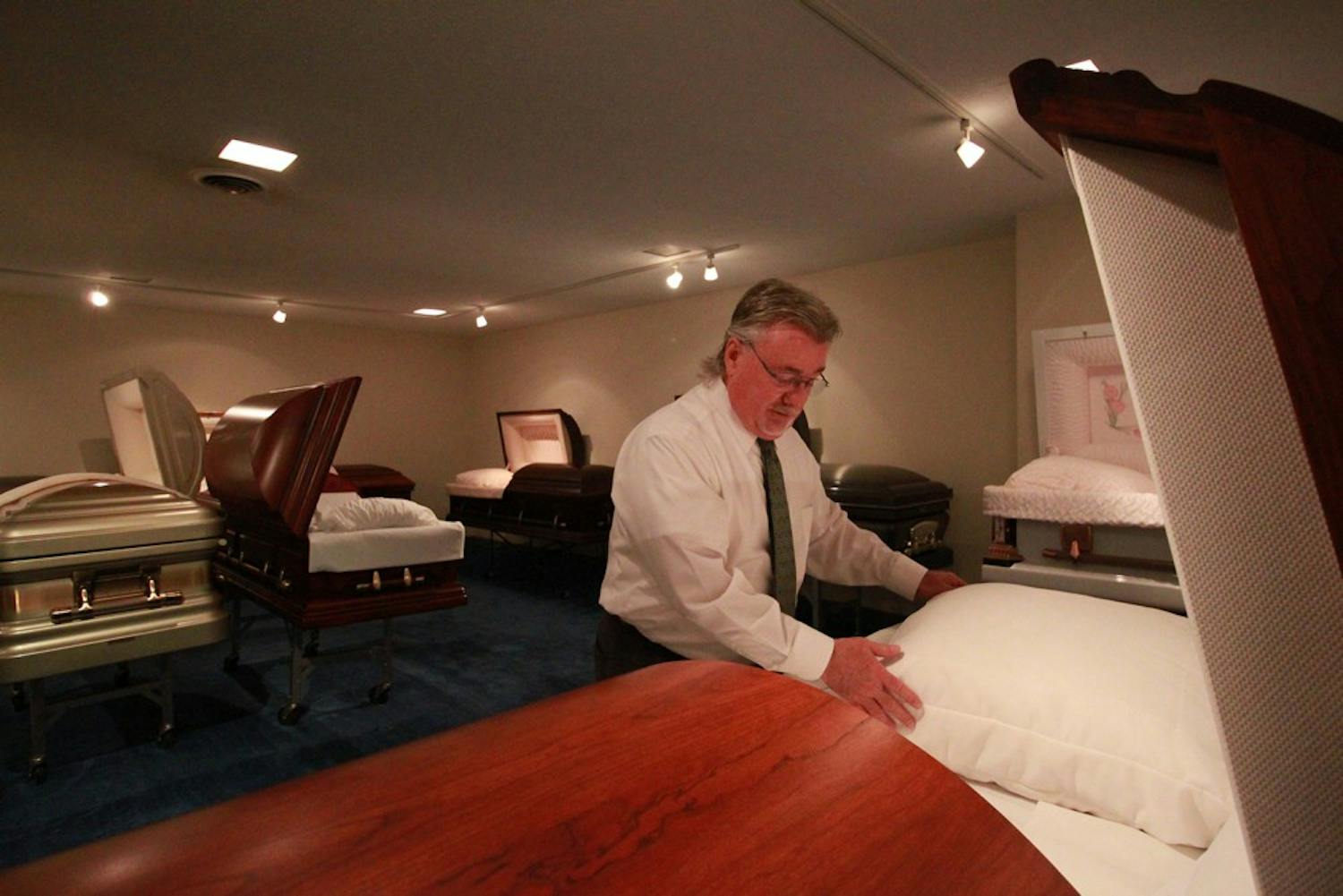 Art Sellers, director of Walker's Funeral Home, explains the casket selection process in the casket selection room of the funeral home. Families select caskets, urns and burial vaults here.