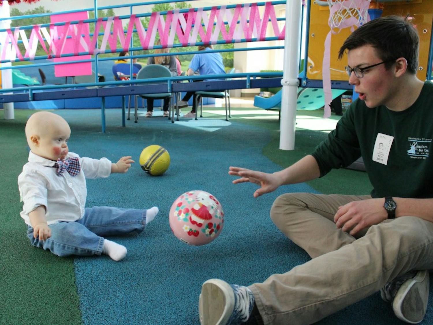 A Carolina for the Kids member plays with a child in UNC Hospitals. Photo courtesy Carolina for the Kids.