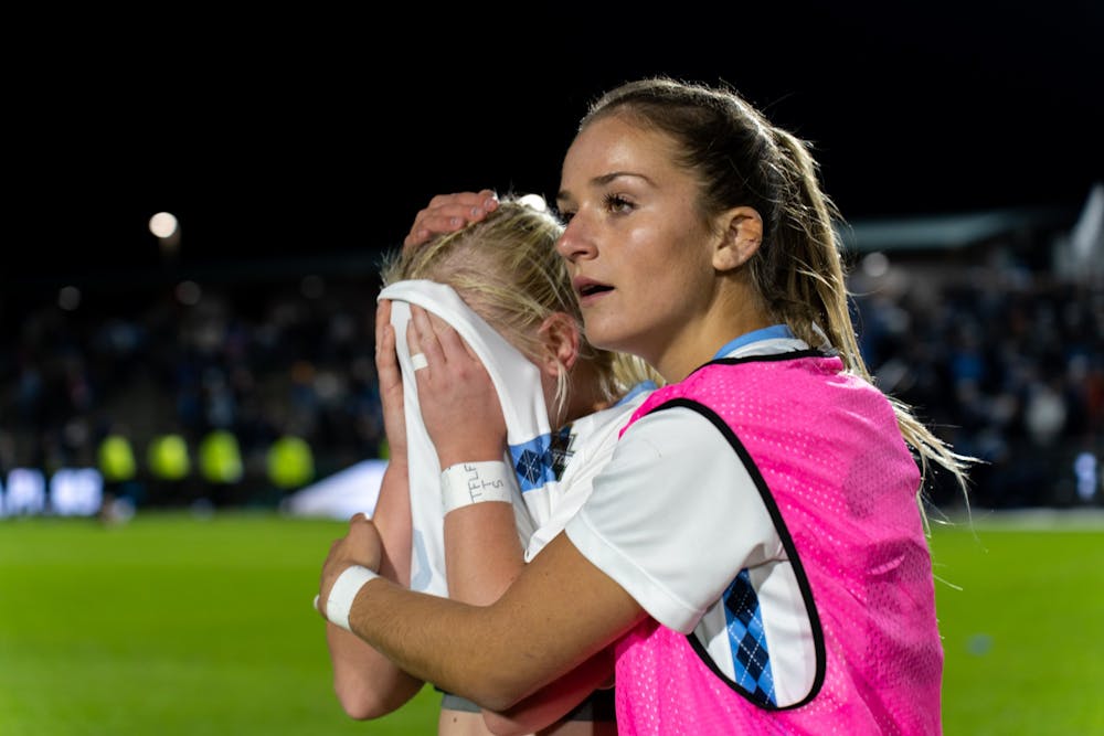 UNC senior forward Aleigh Gambone is comforted after UNC's 3-2 loss to UCLA in the NCAA Finals at WakeMed Soccer Park on Friday, Dec. 5, 2022.