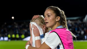 UNC senior forward Aleigh Gambone is comforted after UNC's 3-2 loss to UCLA in the NCAA Finals at WakeMed Soccer Park on Friday, Dec. 5, 2022.