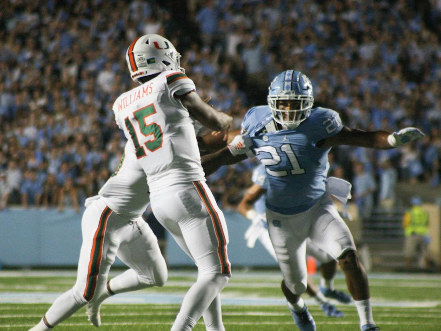 UNC linebacker Chazz Surratt, number 21, is pulled by Miami players on Saturday, Sept. 7, 2019. UNC beat Miami 28-25.