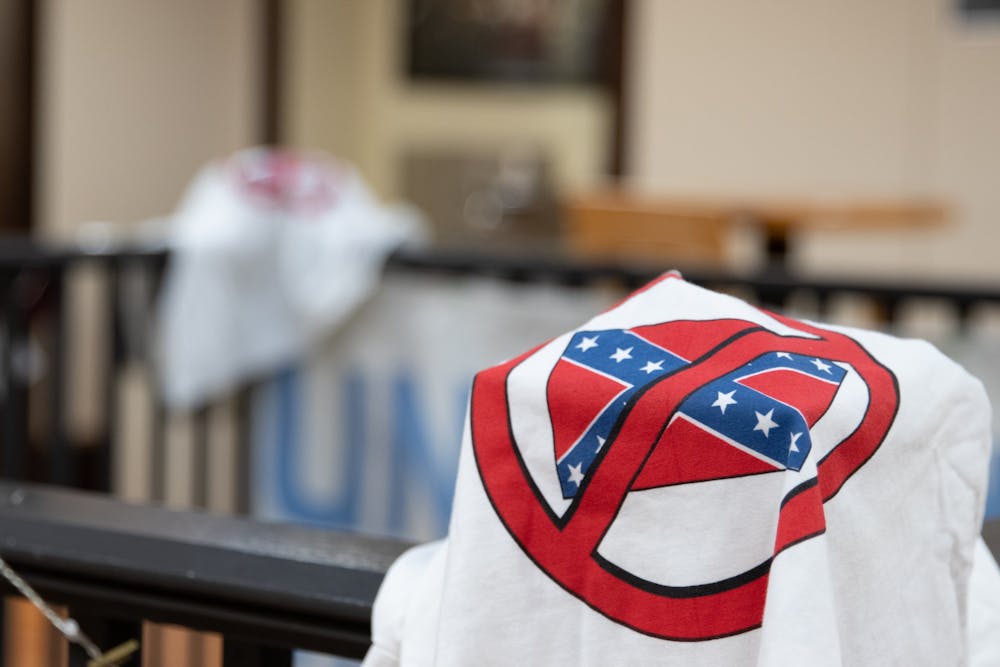 <p>A shirt depicting an anti-confederate symbol is draped over a banister on the second flood of the Campus Y. The shirts were left there by a vandal who broke in over the weekend of Jan. 23-24, 2021.</p>