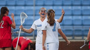 UNC senior defender Emily Nalls (1) celebrates with junior attacker Reilly Casey (7) after Casey scored, assisted by Nalls, during the women's lacrosse game against Liberty on Wednesday, Feb. 15, 2023, at Dorrance Field. UNC beat Liberty 18-6.