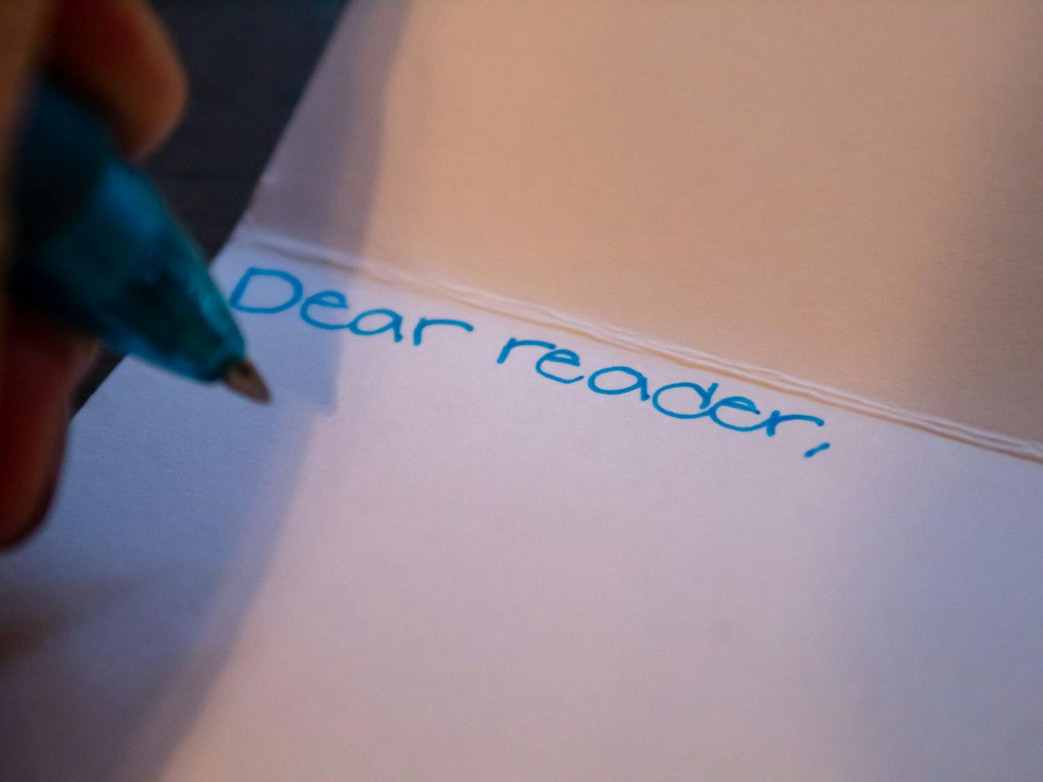 DTH Photo Illustration. A student hand writes a letter.