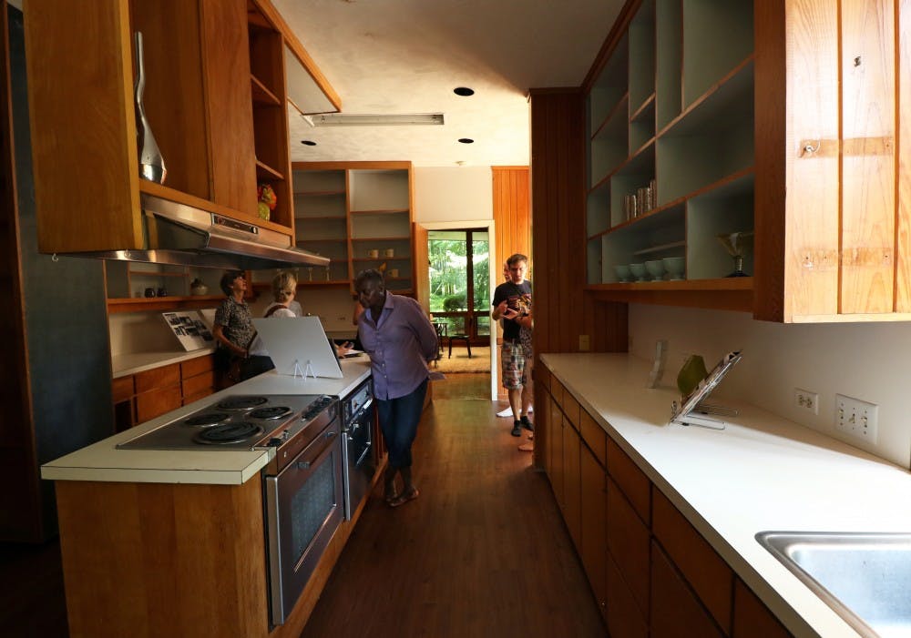 Guests examine information about James Taylor's childhood kitchen as a part of the tour of the recently auctioned home.