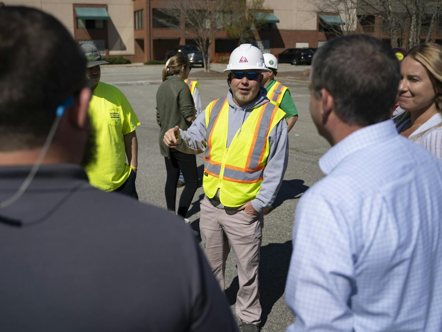 Construction workers talk with town officials and other key players for the University Place construction at the project’s groundbreaking ceremony on Monday, Mar. 6, 2023.